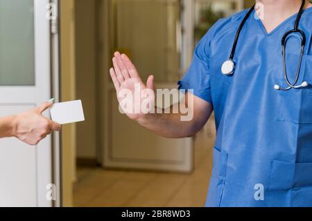 La mezza età, bianco caucasico, maschio medico in frega con uno stetoscopio rifiutando carta bianca, ospedale sfocata corridoio in background Foto Stock