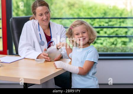 Pediatra femmina in bianco camice da laboratorio candys ha per una bambina Foto Stock