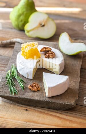 Formaggio Camembert con pere e noci sul pannello di legno Foto Stock