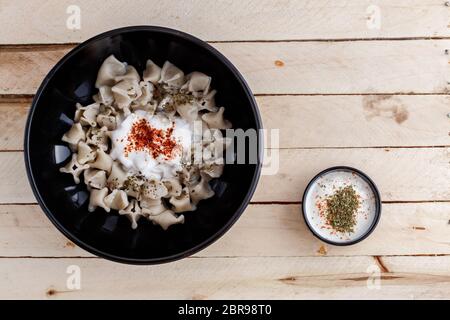 Bagno turco Manti manlama sulla piastra con il peperone rosso, il sugo di pomodoro, yogurt e menta Foto Stock