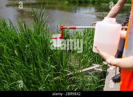 Prelevare campioni di acqua per le prove di laboratorio. Il concetto - analisi della purezza dell'acqua, ambiente, ecologia Foto Stock