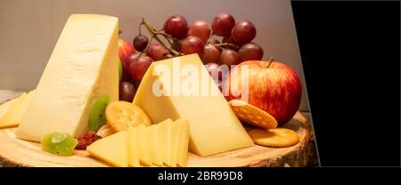 Formaggio gruviera con varietà di frutta e cracker sul piatto di legno in linea buffet, panoramiche classifica di grandi dimensioni di raccolto Foto Stock