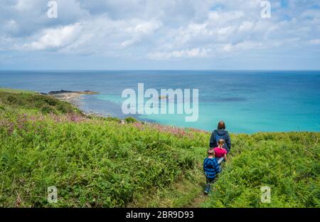 Famiglia camminando su un piccolo sentiero lungo la splendida costa della Cornovaglia vicino a St Ives in Cornovaglia, England, Regno Unito Foto Stock