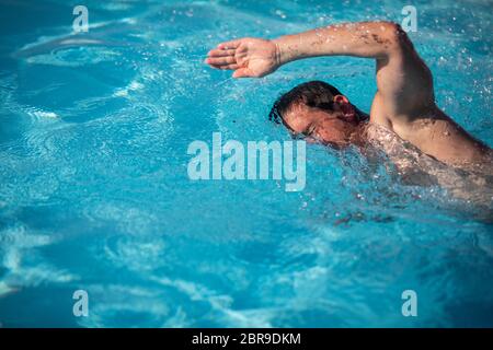 Nuotatore nuoto crawl in una piscina esterna - mantenersi in forma Foto Stock