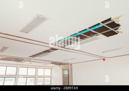 riparare il tubo di scarico dell'acqua sull'edificio degli uffici interni del soffitto in gesso Foto Stock