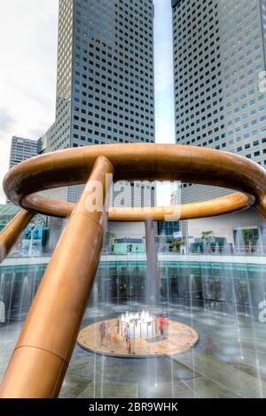 SINGAPORE - 26 MARZO 2015 : i turisti camminano verso la Fontana della ricchezza credevano di impartire fortuna a chiunque la circondasse 3 volte e toccandola il gugnone Foto Stock