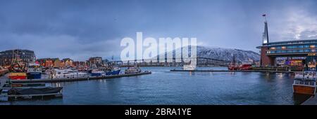Tromso, Norvegia - Dicembre 2018 : il porto e il porto con il famoso Ponte di Tromso attraverso Tromsoysundet stretto in background Foto Stock