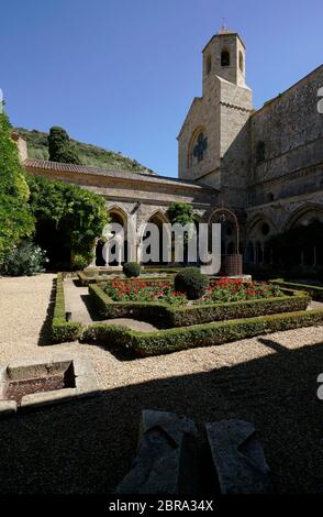 Chiostro e giardino di Abbaye Sainte-Marie de Fontfroide o Fontfroide Abbazia con la torre della chiesa sullo sfondo. Narbonne, Aude Occitanie, Francia, Foto Stock