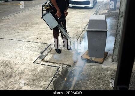 Lavoratore che fogging zona residenziale e sanitaria fognaria con insetticidi per uccidere Aedes zanzara che si incrociano terra, concetto Zika virus e dengue febbre Foto Stock