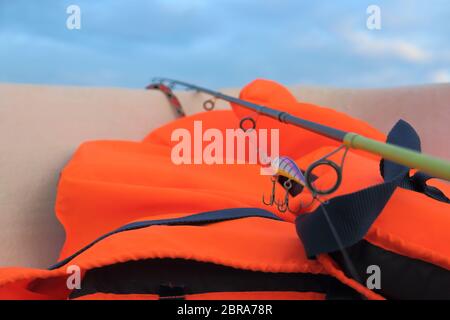 Orange giubbotto di salvataggio è necessario quando la cattura di pesci predatori in mare Foto Stock