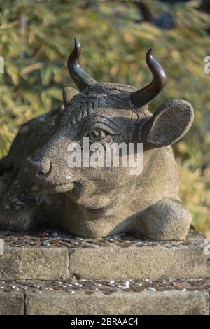 Buddista statua di pietra di un toro giacente con monete poste come offerta sulla sua base nel tempio Enryaku Ryôgen di Monaco sul Monte Hiei vicino a Kyoto, J Foto Stock