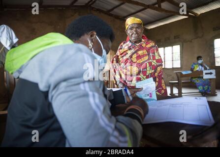 Gitega, Burundi. 20 Maggio 2020. Un membro del personale della Commissione elettorale nazionale indipendente burundese verifica l'identità di un elettore nella provincia di Gitega, nel Burundi centrale, il 20 maggio 2020. Mercoledì gli elettori burundesi sono andati alle urne per eleggere un nuovo presidente, membri dell'Assemblea nazionale e consiglieri distrettuali. (Foto di Evrard Ngendakumana/Xinhua) Credit: Xinhua/Alamy Live News Foto Stock