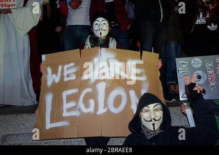 La "marcia della maschera del lionio" vede le proteste indossare V per le maschere di Guy Fawkes stile vendetta e dimostra contro l'austerità, la violazione dei RI civili Foto Stock