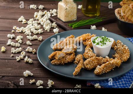 Le strisce di pollo nel pangrattato popcorn, con deliziosi aglio dip panini e toast Foto Stock