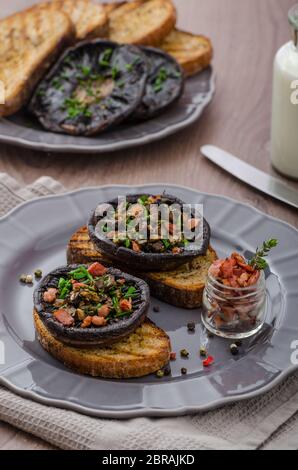 Portobello farcito con erbe, pancetta e aglio, delizioso pane all'aglio croccante tostato Foto Stock