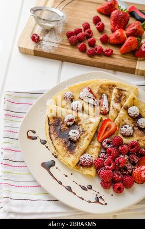 Frittelle fatte in casa con riduzione di balsamico e frutta fresca, fragole e lamponi Foto Stock