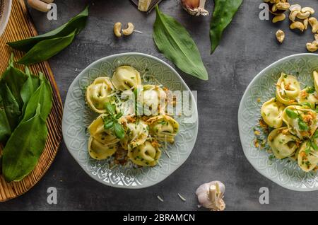 Aglio Tortellini ripieno e spinaci con cipolla fritta Foto Stock