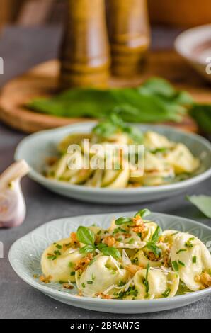 Aglio Tortellini ripieno e spinaci con cipolla fritta Foto Stock