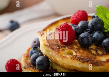 Frittelle con frutti di bosco e menta fresca frutta e latte Foto Stock