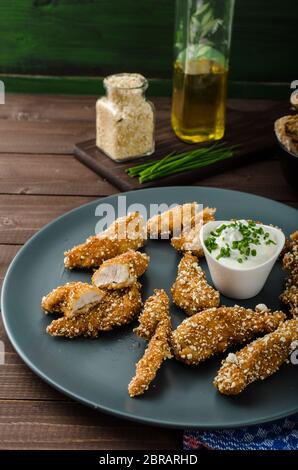 Le strisce di pollo nel pangrattato popcorn, con deliziosi aglio dip panini e toast Foto Stock