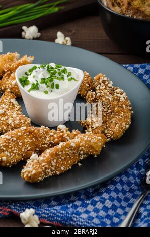 Le strisce di pollo nel pangrattato popcorn, con deliziosi aglio dip panini e toast Foto Stock