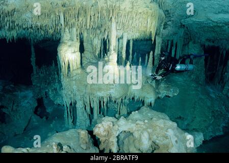 Sidemount tecnico subacqueo nuotare intorno a formazioni di pietra calcarea unico nel cenote Dreamgate in Messico. Foto Stock