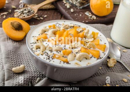 Albicocche domestico musli yogurt con il latte e croccante di dadi e sementi sane chia Foto Stock