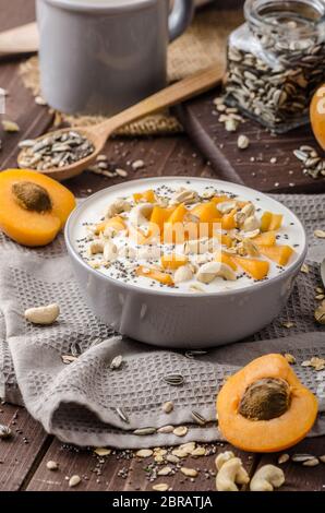 Albicocche domestico musli yogurt con il latte e croccante di dadi e sementi sane chia Foto Stock