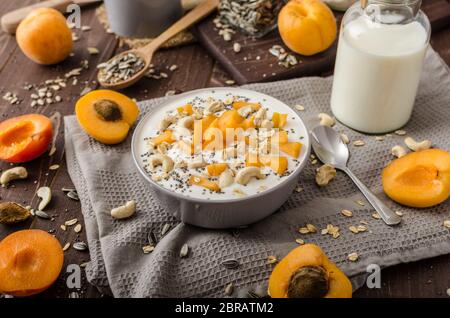 Albicocche domestico musli yogurt con il latte e croccante di dadi e sementi sane chia Foto Stock