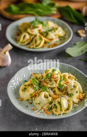 Aglio Tortellini ripieno e spinaci con cipolla fritta Foto Stock