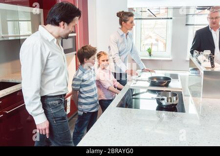 Expert spiegando nuova cucina di famiglia in cerca di uno rivolto ad alcune interessanti caratteristiche del modello corrente Foto Stock