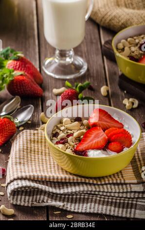 Farina di avena con yogurt fragole fresche e dadi, sana colazione ricca di vitamine Foto Stock