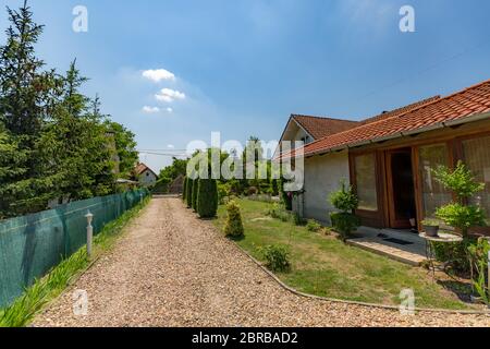 Casa di campagna inglese, vialetto e recinzione verde vicino al vicino Foto Stock
