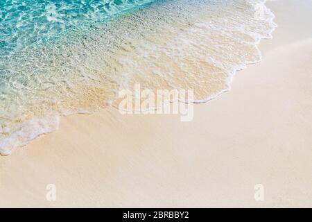 Onda morbida di colore blu oceano su una spiaggia di sabbia. Sfondo. Foto Stock