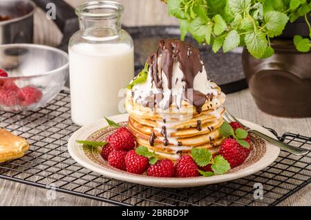 Frittelle americane con icecream e cioccolato, erbe e bacche intorno Foto Stock