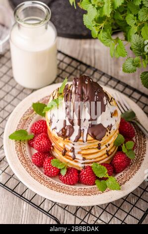 Frittelle americane con icecream e cioccolato, erbe e bacche intorno Foto Stock