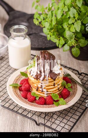 Frittelle americane con icecream e cioccolato, erbe e bacche intorno Foto Stock