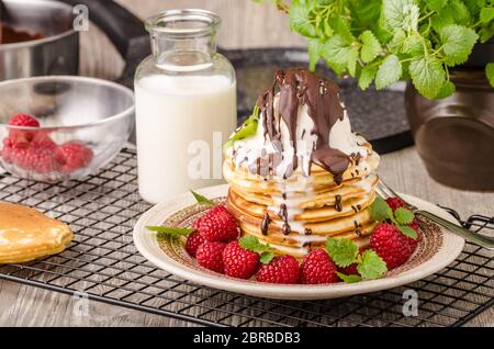 Frittelle americane con icecream e cioccolato, erbe e bacche intorno Foto Stock