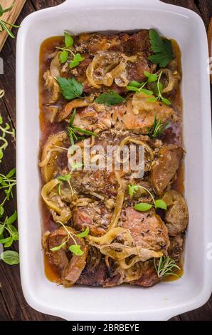 Tritare la carne di maiale al forno con mele, erbe aglio e cipolla Foto Stock