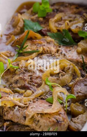 Tritare la carne di maiale al forno con mele, erbe aglio e cipolla Foto Stock