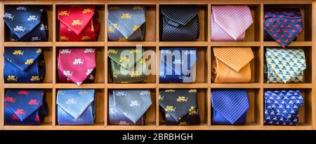 Vetrina con cravatte multicolore. Vista di diversi colori cravatte in vetrina. Uomo multicolore. Vetrina di cravatte arrotolate in negozio. Le lege avvolte Foto Stock