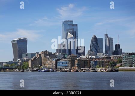 Skyline di London City, estate 2020, da sud-est. Mostra le tradizionali chiatte a vela ormeggiate lungo il lungomare di Wapping (centro). Foto Stock