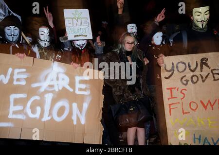 La "marcia della maschera del lionio" vede le proteste indossare V per le maschere di Guy Fawkes stile vendetta e dimostra contro l'austerità, la violazione dei RI civili Foto Stock
