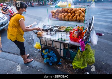 Venditore di cibo di strada, facendo banh mi, baguettes, ho Chi Minh City, Vietnam, Asia Foto Stock