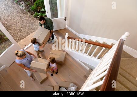 Coppia caucasica e i loro figli che arrivano alla loro nuova casa Foto Stock