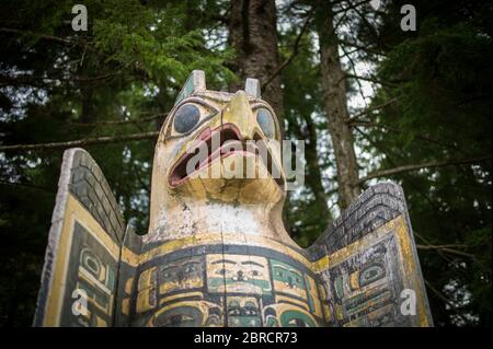 Il Totem bight state Historical Park, Ketchikan, Alaska, USA, mostra la replica e i pali del totem dei nativi americani restaurati, tra cui il marcatore della tomba dell'aquila Foto Stock