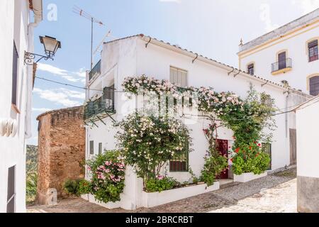 Vista di una bella casa bianca con fiori nella facciata nel villaggio di Zufre, Sierra de Aracena, Huelva, Spagna Foto Stock