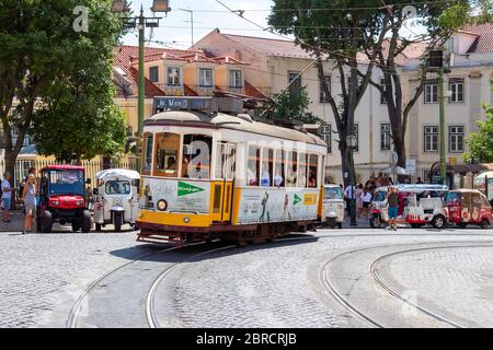 Lisbona, Portogallo - 15 Luglio 2019: il famoso tram giallo 28 passando davanti al duomo di Santa Maria a Lisbona, Portogallo Foto Stock