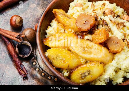 Porridge di miglio con banane e noci. Colazione sana Foto Stock