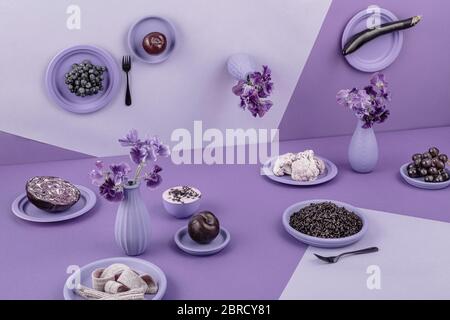 Tavolo in viola, prospettiva, surreale, melanzane, cavolo rosso, riso, yogurt, uva, mela, fiori, cavolfiore, natura morta, fotografia alimentare Foto Stock